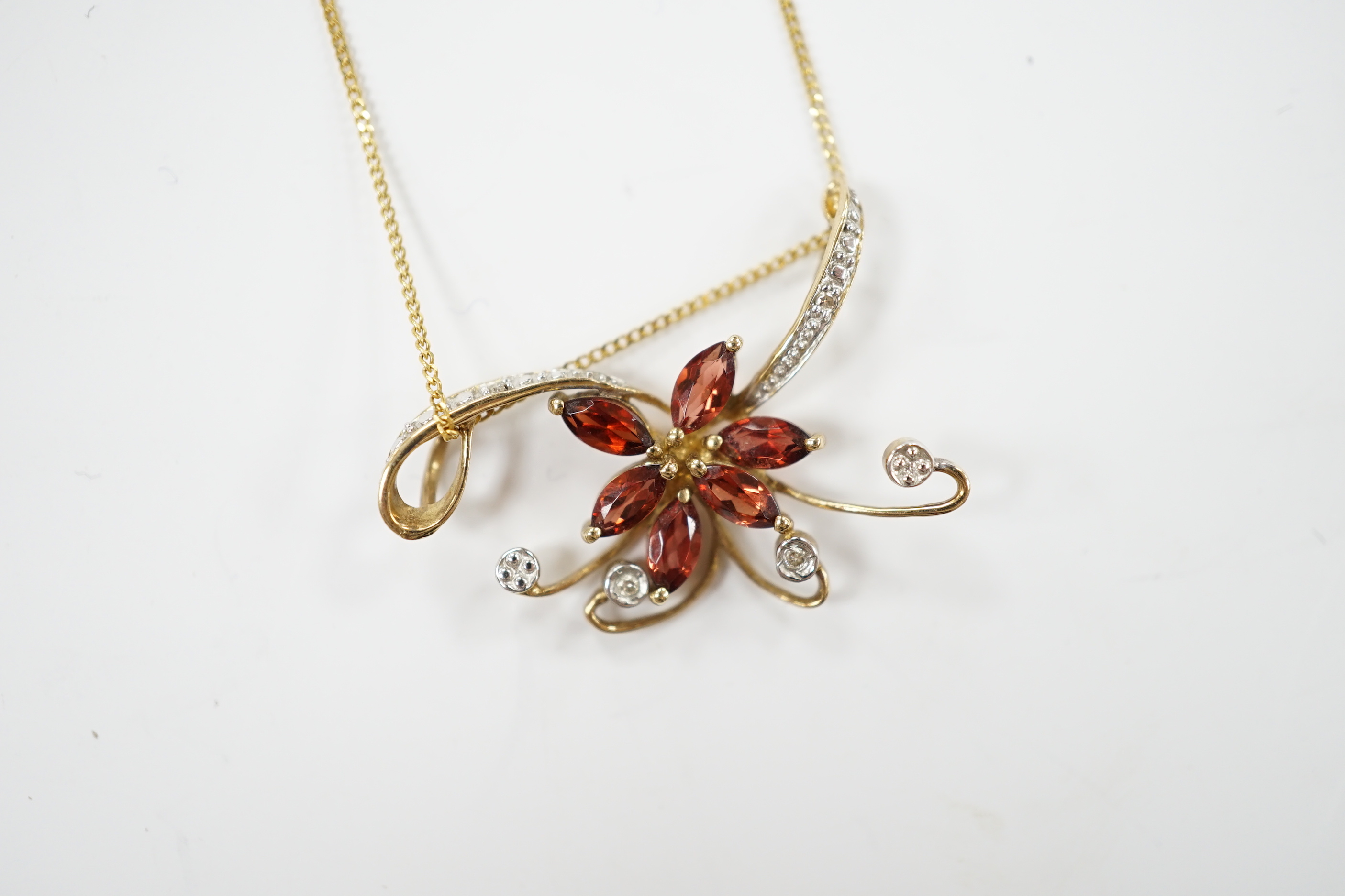 A modern 9ct gold and gem set foliate pendant on chain, pendant 30mm, gross weight 2.6 grams.